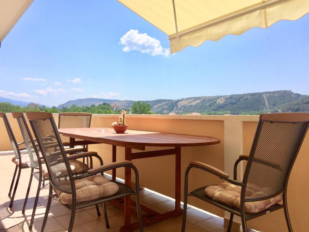 een tafel en stoelen op een balkon met uitzicht bij Apartments Iva in Lopar