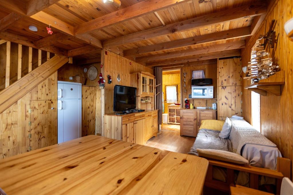 a kitchen and living room with a table in a cabin at Chalet Sérénité - Tranquillité et Très Belle Vue in Puyvalador