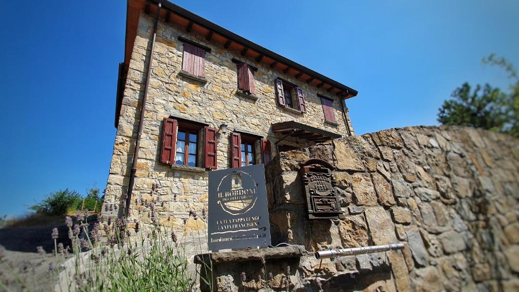 a stone building with a sign in front of it at Il Bordone del Pellegrino in Terenzo