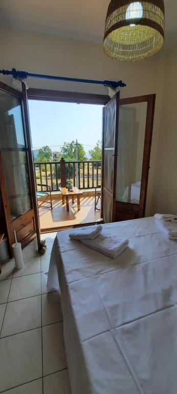 - une chambre avec un grand lit et un balcon dans l'établissement BS Village, à Metamórfosi