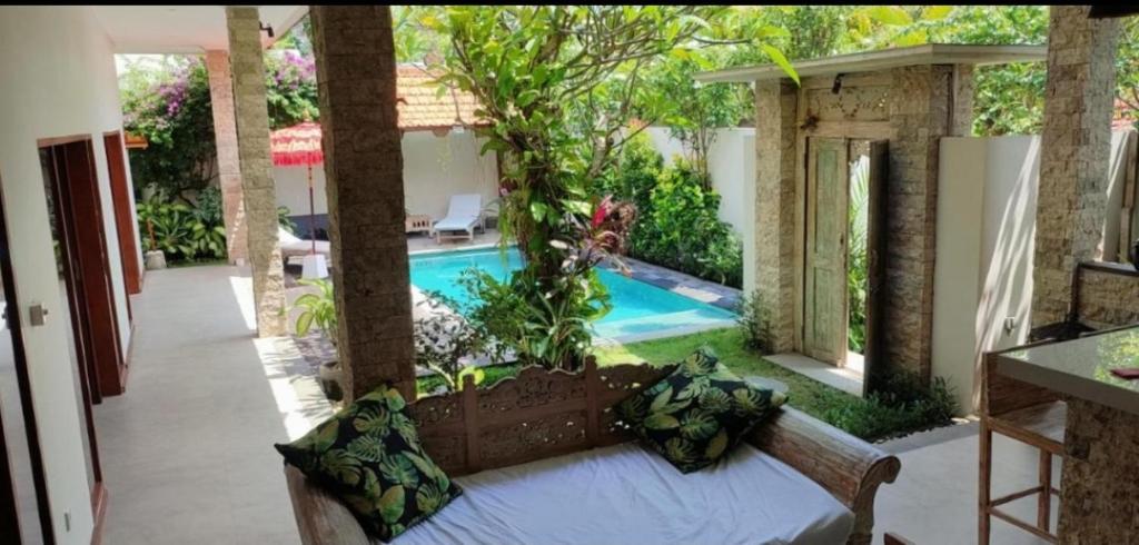 a bedroom with a bed and a swimming pool at Villa Yudha, Canggu in Canggu