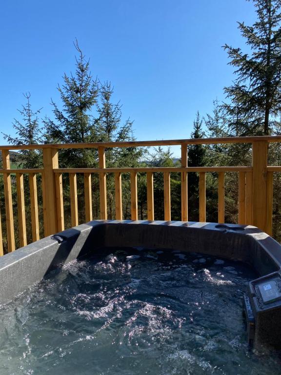 a hot tub in a backyard with a wooden fence at Chestnut Lodge with Hot Tub in Cupar