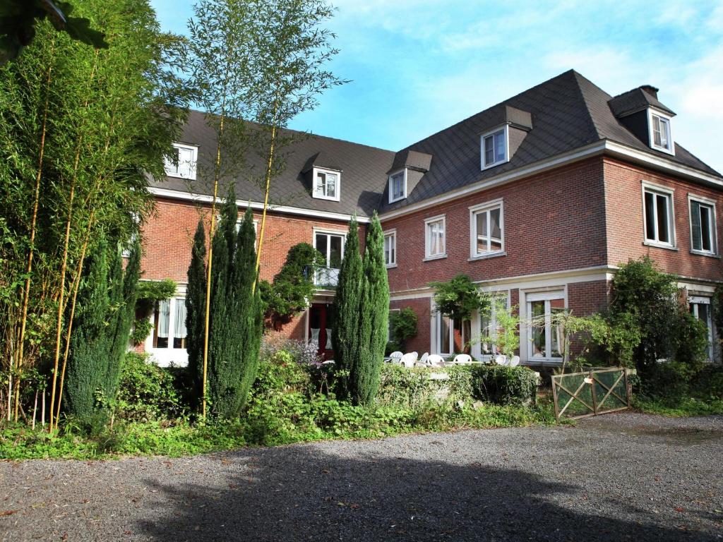 una grande casa in mattoni con alberi di fronte di Comfortable Mansion in Doomkerke near Forest a Ruiselede