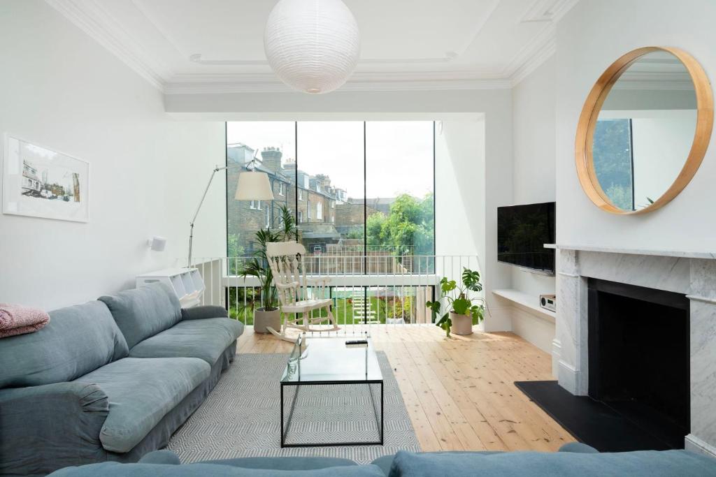 a living room with a couch and a fireplace at Beautiful 4BR Home in Vibrant Haringey in London