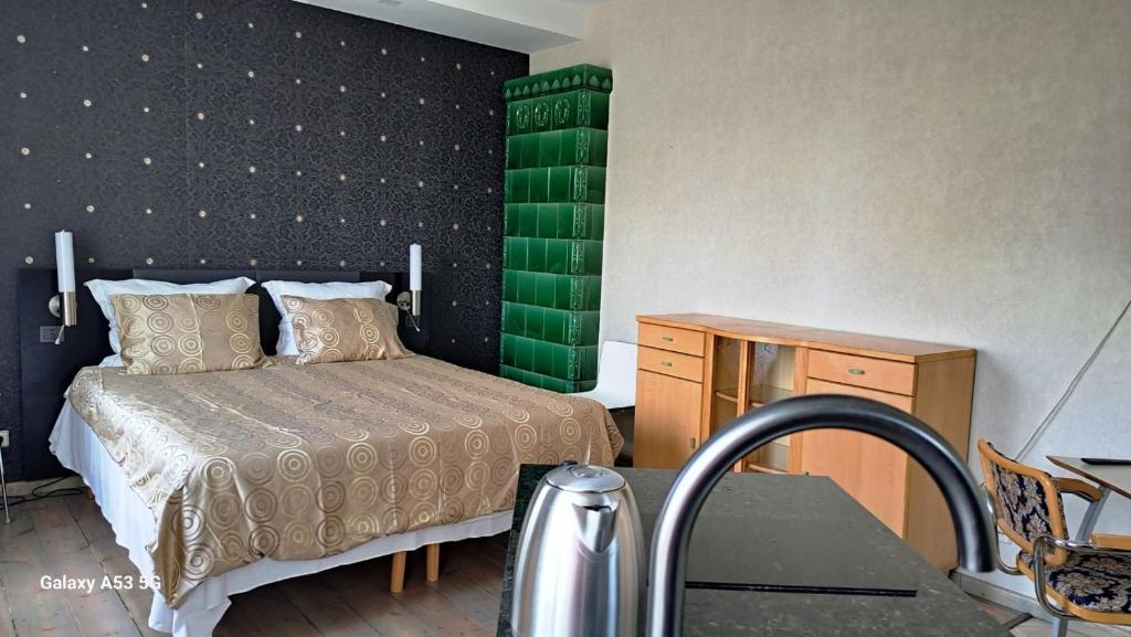 1 dormitorio con cama y pared verde en KaunasInn, en Kaunas