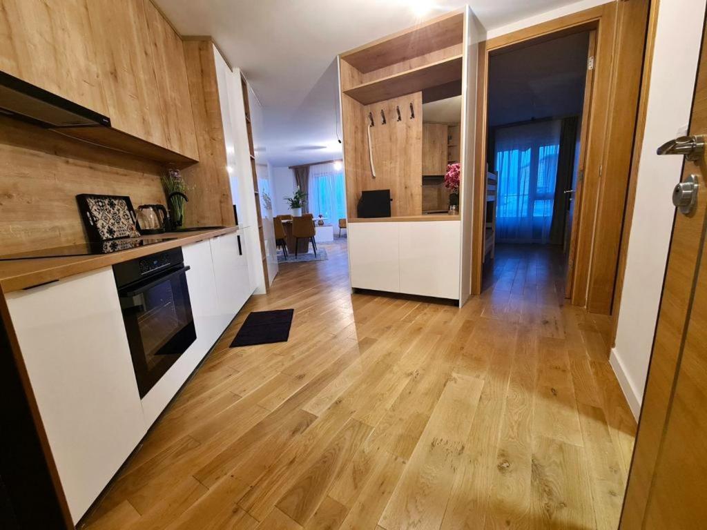 een keuken met witte kasten en een harde houten vloer bij River Walk Apartman in Sarajevo