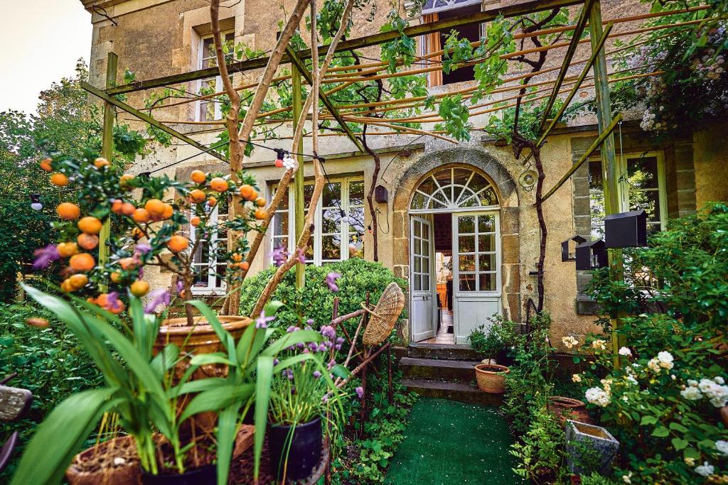 a house with a bunch of plants in front of it at Le Couvent in LʼHermenault