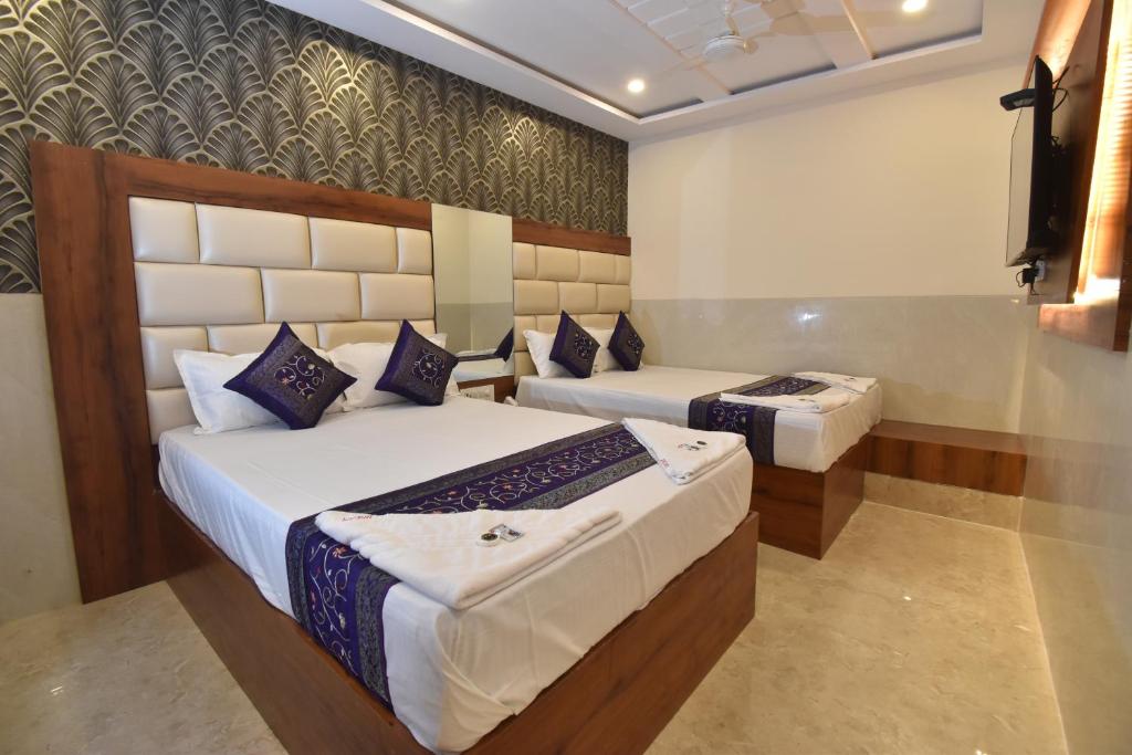 a hotel room with two beds and a television at Hotel Dream Palace Residency - Near LBS Marg in Mumbai