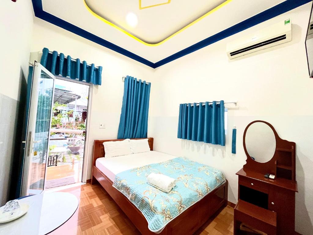 a bedroom with a bed and a mirror at Minh Khoi Guest House in Mui Ne