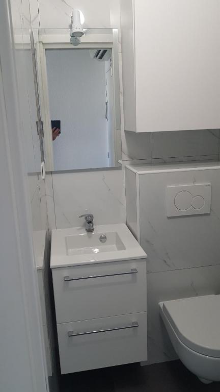 a white bathroom with a sink and a toilet at studio à 2 mn à pied de la plage in Nice