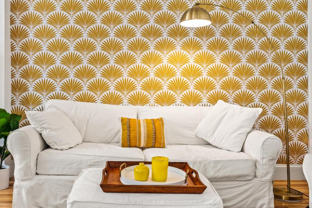 a living room with a white couch and a wall at Casa Lovett - Tropical Bungalow in Saint Augustine