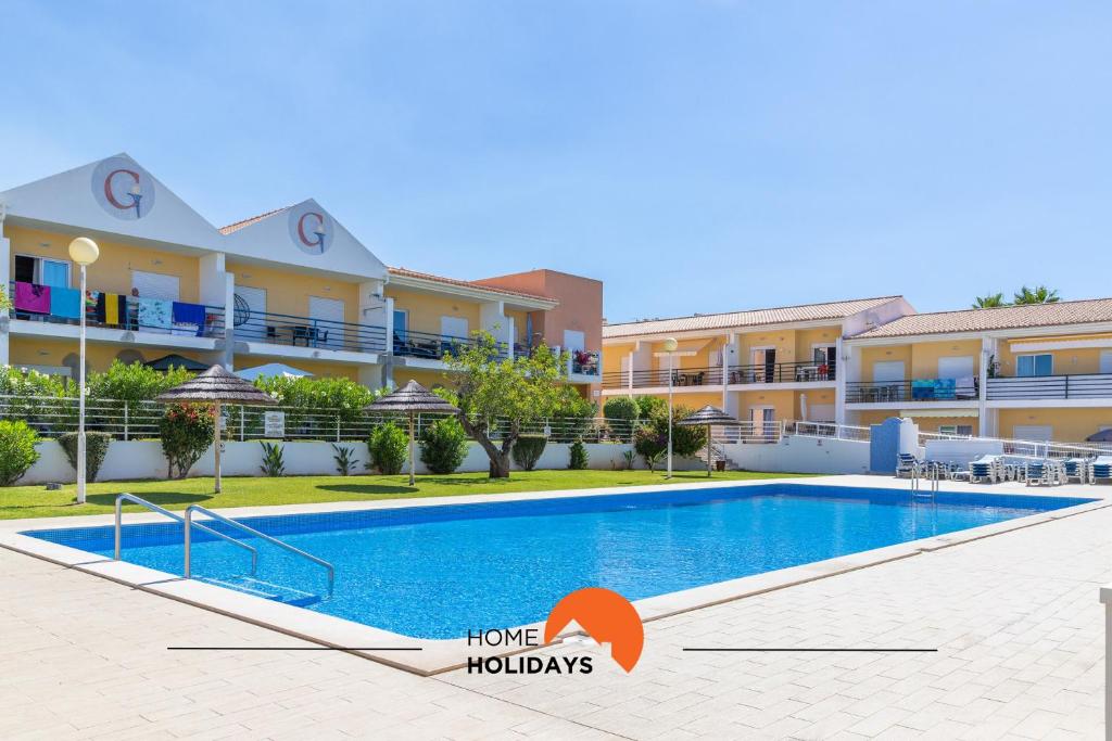 an image of a swimming pool in front of a building at #123 T2 Pão das Areias by Home Holidays in Galé