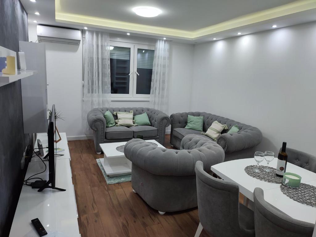 a living room with couches and a table at Novak apartman in Subotica