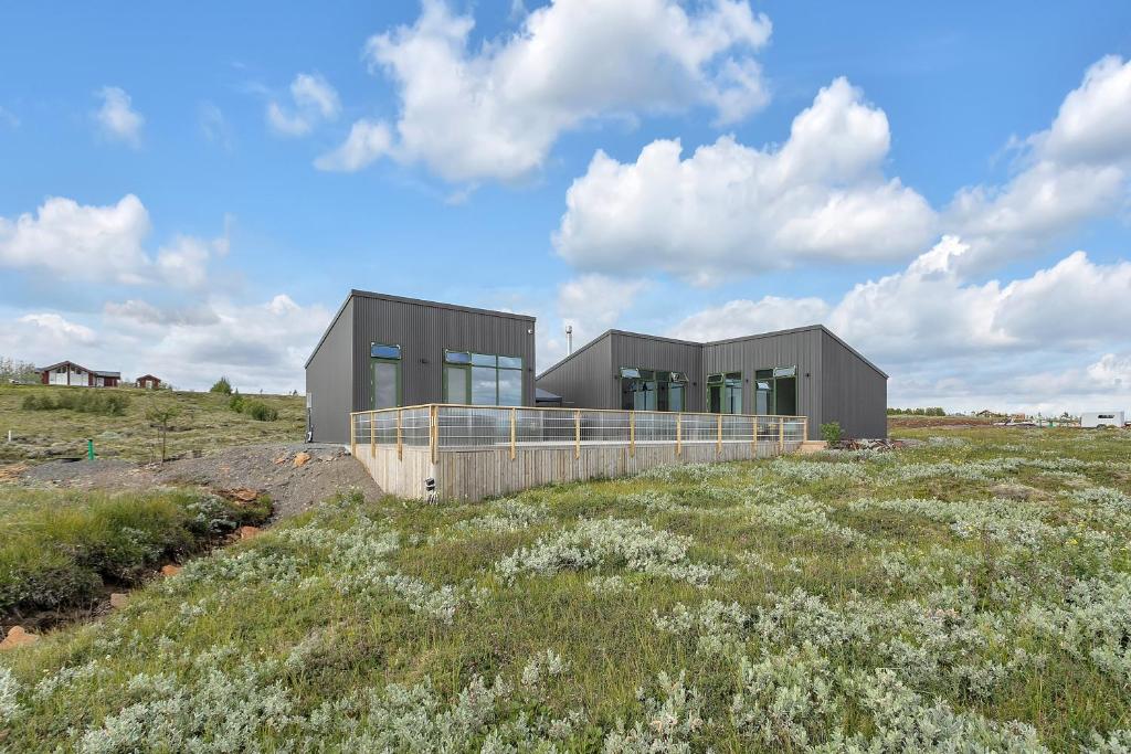 a house on top of a field of grass at 4bed 4bath Sauna & Hot tub in Reykholt