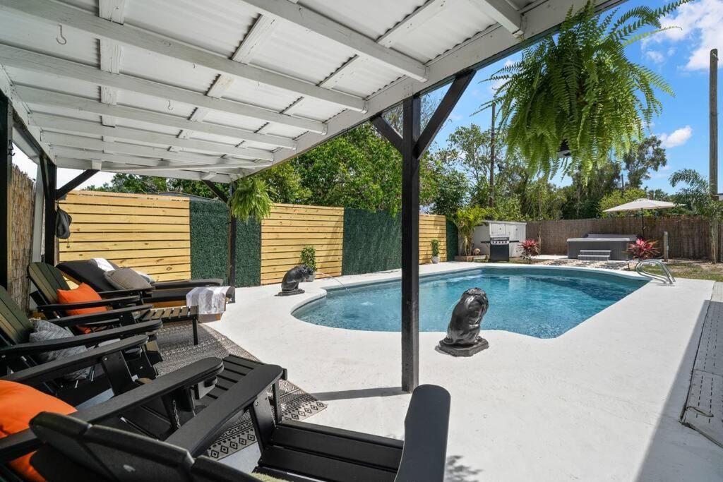 una piscina con sillas y una pérgola en Perfect Pool & Hot Tub Retreat, en Pinellas Park