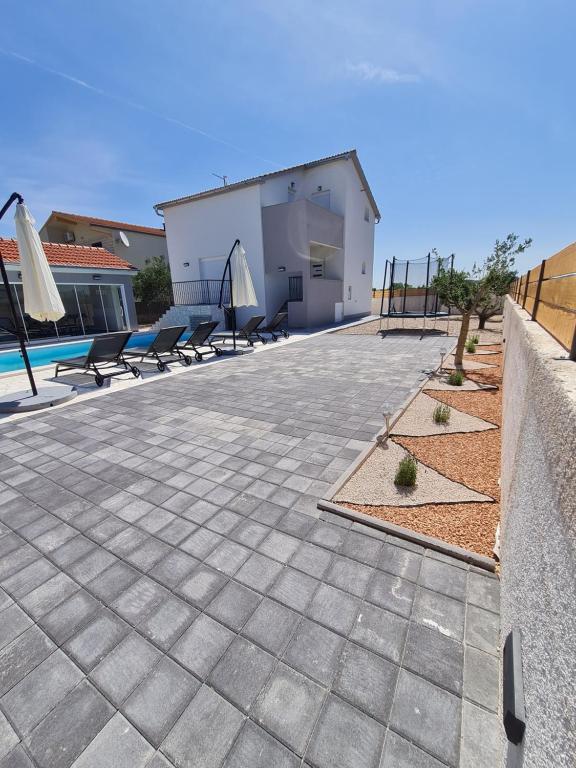 a patio with chairs and a fence and a pool at Kuca za odmor Feniks in Polača