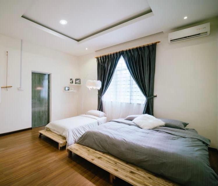 a bedroom with two beds and a window at 一间民宿 A Homestay in Semporna