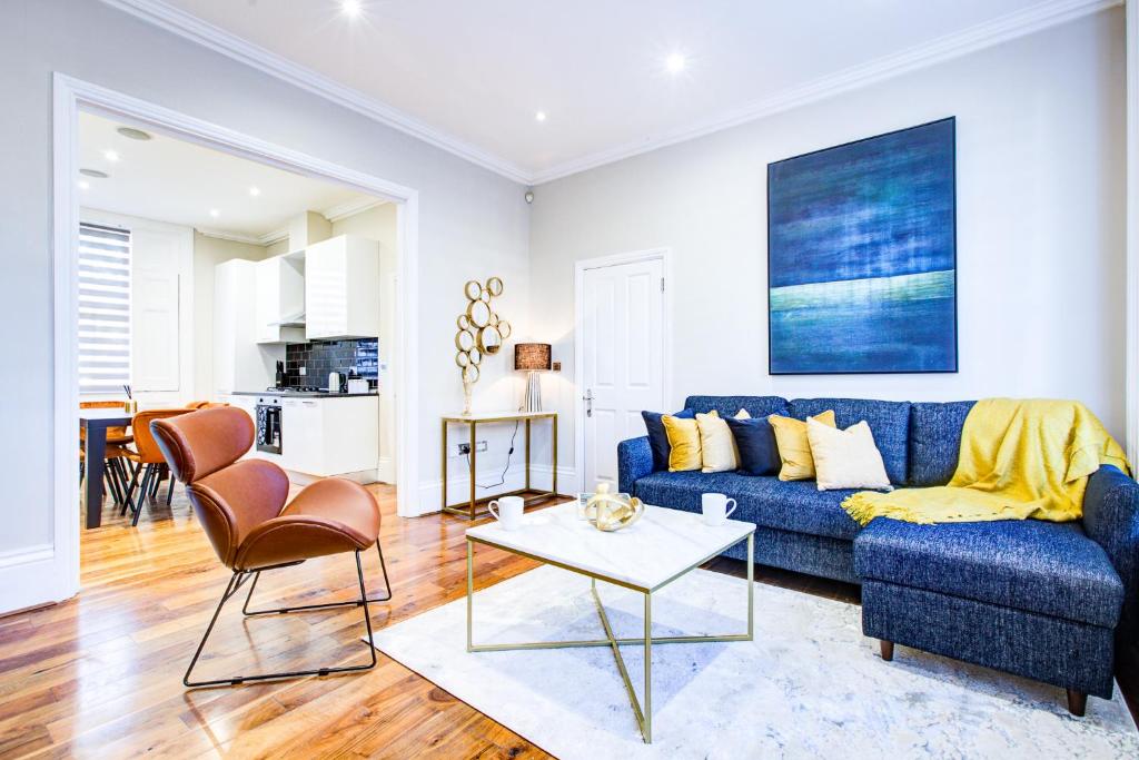 a living room with a blue couch and a table at Hybrid Resi - Battersea in London
