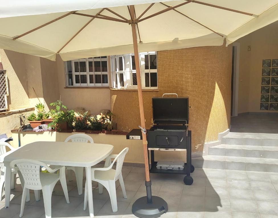 een witte tafel met een barbecue op een patio bij La Casa Alegre in Alicante