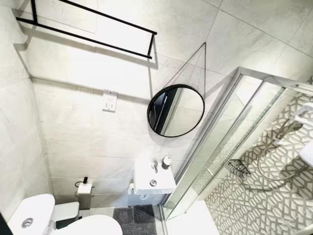 ein Bad mit einem Waschbecken und einem Spiegel in der Unterkunft Studios next to Emirates Stadium in London