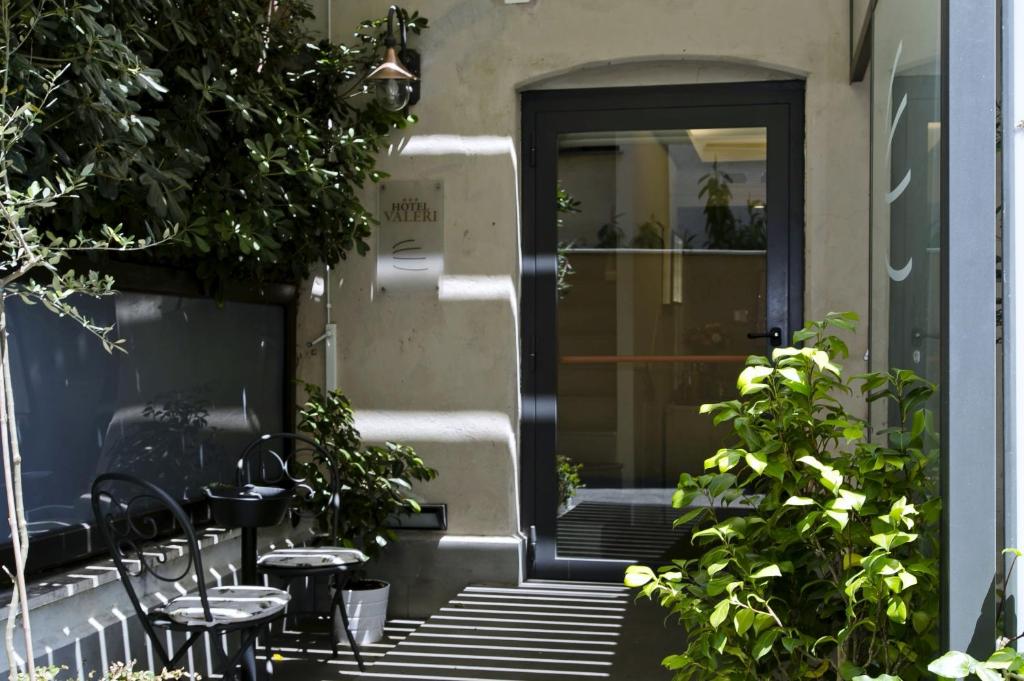 ローマにある1 ヴィア デイ ヴァレリのドアの前にテーブルと椅子が備わるパティオ