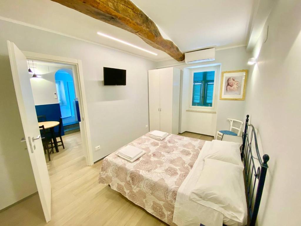 a bedroom with a bed and a table in a room at Apartment La Scogliera - Riomaggiore in Riomaggiore