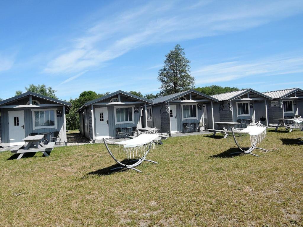 una fila de cabañas con sillas en el césped en New holiday homes for 2 people in Dziwnówek en Dziwnówek