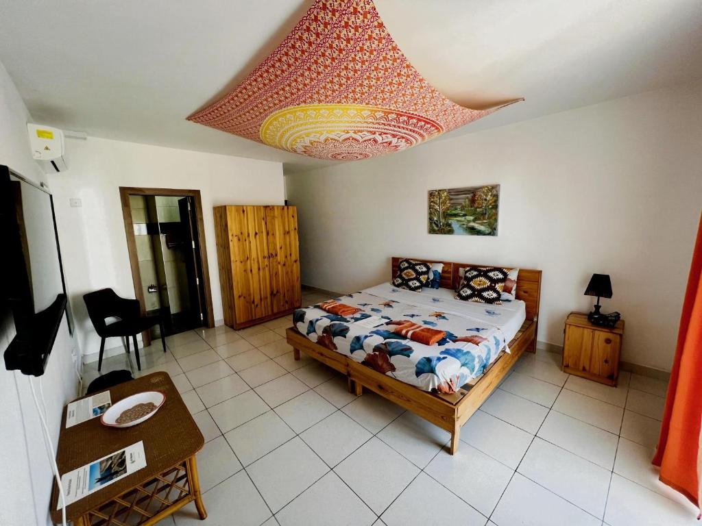 a bedroom with a bed and a table and a chandelier at All Nations Holiday Home in Għajnsielem