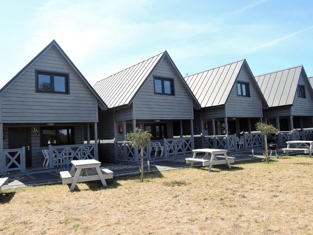a row of houses with picnic tables in front of them at Holiday Home in Dziwnówek by Sea and Lake in Dziwnówek