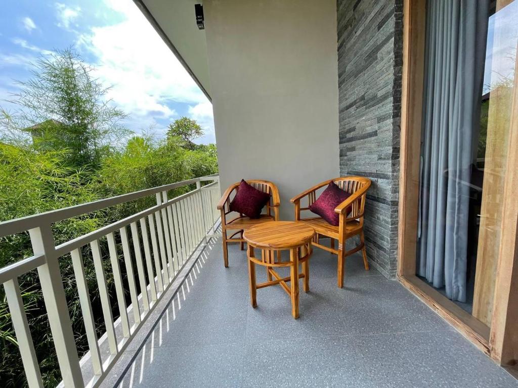 2 sillas y una mesa en el balcón en Kasapa Inn en Ubud