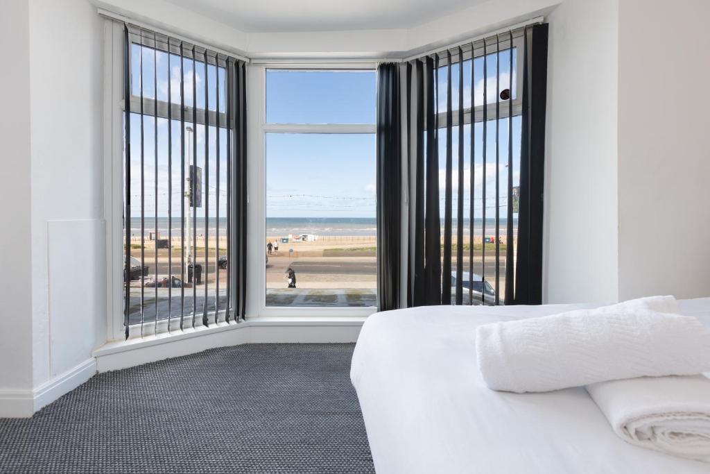 a bedroom with a bed and a view of the beach at Blackpool Resort Hotel in Blackpool