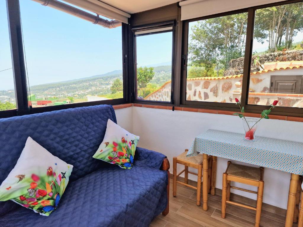 ein Wohnzimmer mit einem blauen Sofa und einem Tisch in der Unterkunft Casa Rural Giovanni & Rosa B Icod de los Vinos by HRTenerife Net in Icod de los Vinos