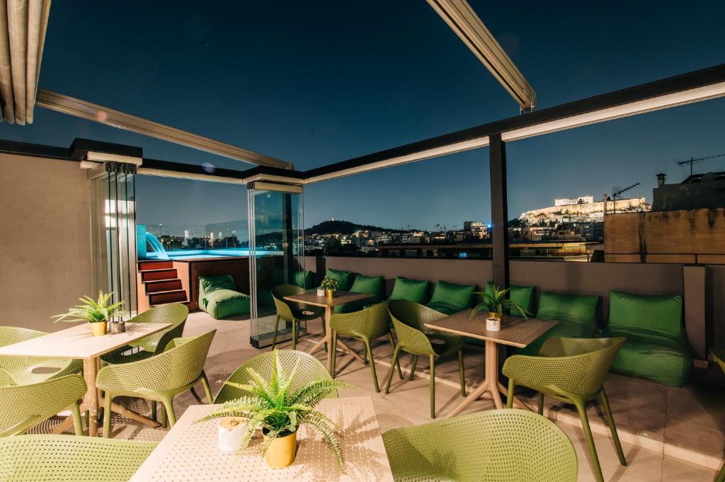 a patio with tables and chairs and a view of the city at Athesense Suites in Athens