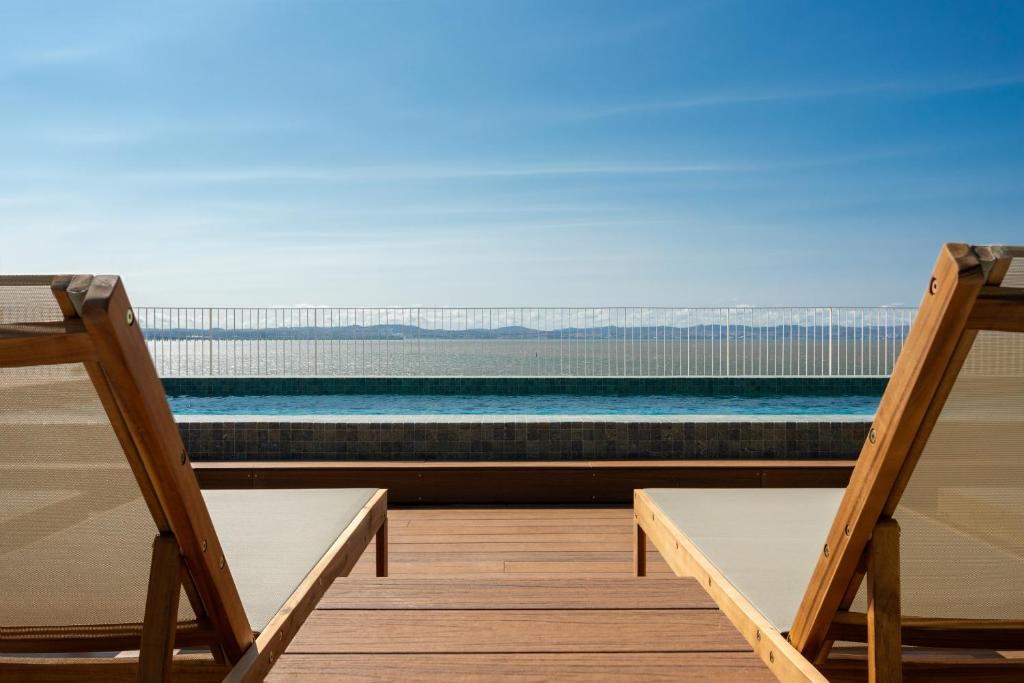 アルコシェテにあるUpon Vila - Alcochete Hotelの海の景色を望むデッキ(椅子2脚付)