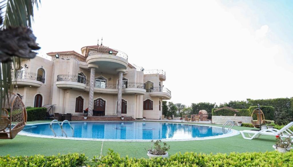 a large mansion with a large swimming pool at Villa king mariot in Alexandria