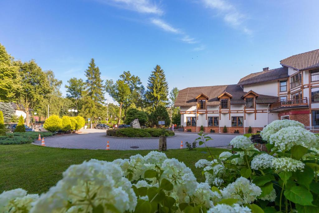 a house with a yard with flowers in front of it at Hotel Wisła Premium in Wisła