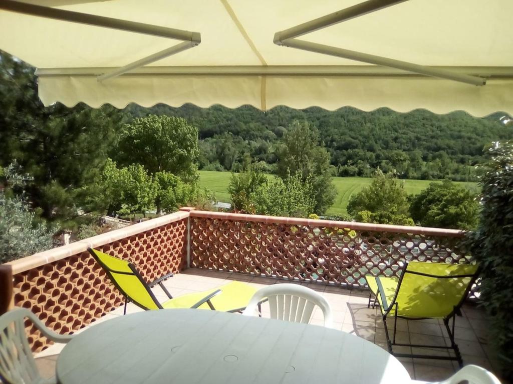 a patio with a table and chairs on a balcony at Le seringat 46 in Saint-Martin-de-Brômes