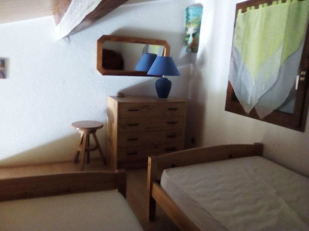 a bedroom with a bed and a dresser and a mirror at Le seringat 46 in Saint-Martin-de-Brômes