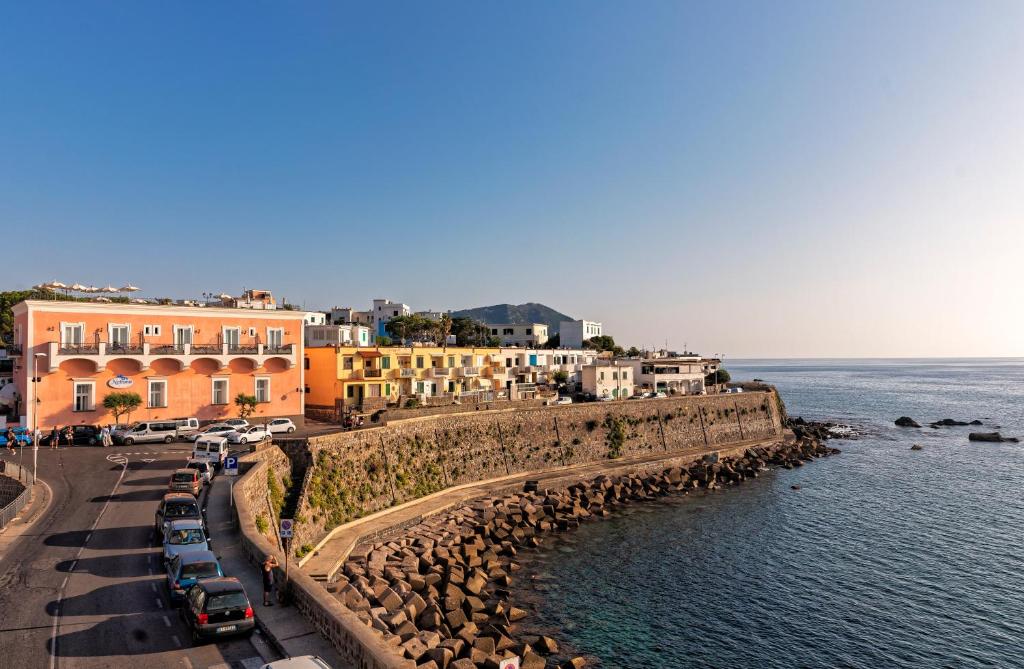 a group of cars parked on a road next to the water at Hotel Nettuno in Ischia