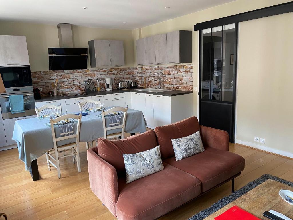 un salon avec un canapé et une cuisine avec une table dans l'établissement LE LOFT SOMMEILLER 19*** Près du Lac, à Annecy