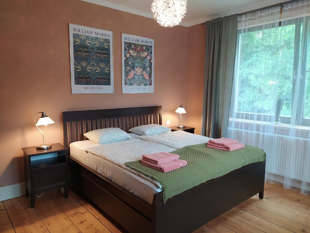 1 dormitorio con 1 cama con 2 toallas rosas en Apartmány Pod hradbami Křivoklát, en Křivoklát