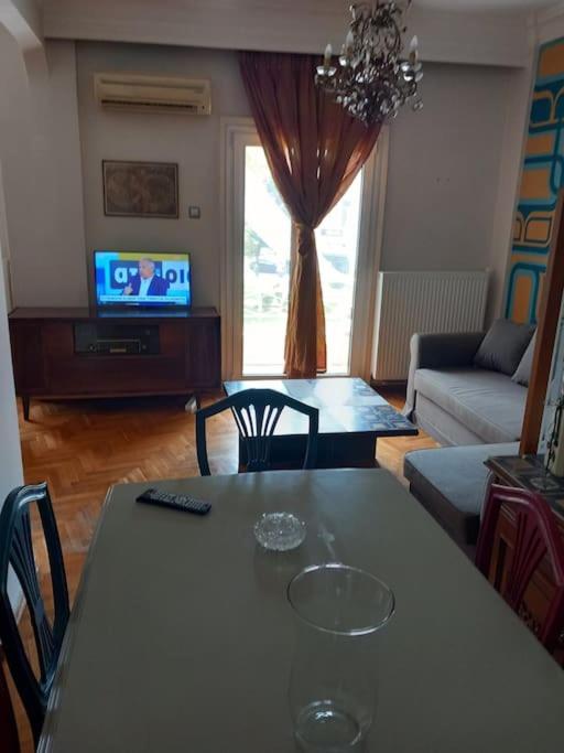 een woonkamer met een tafel en een televisie bij Retro Central in Thessaloniki