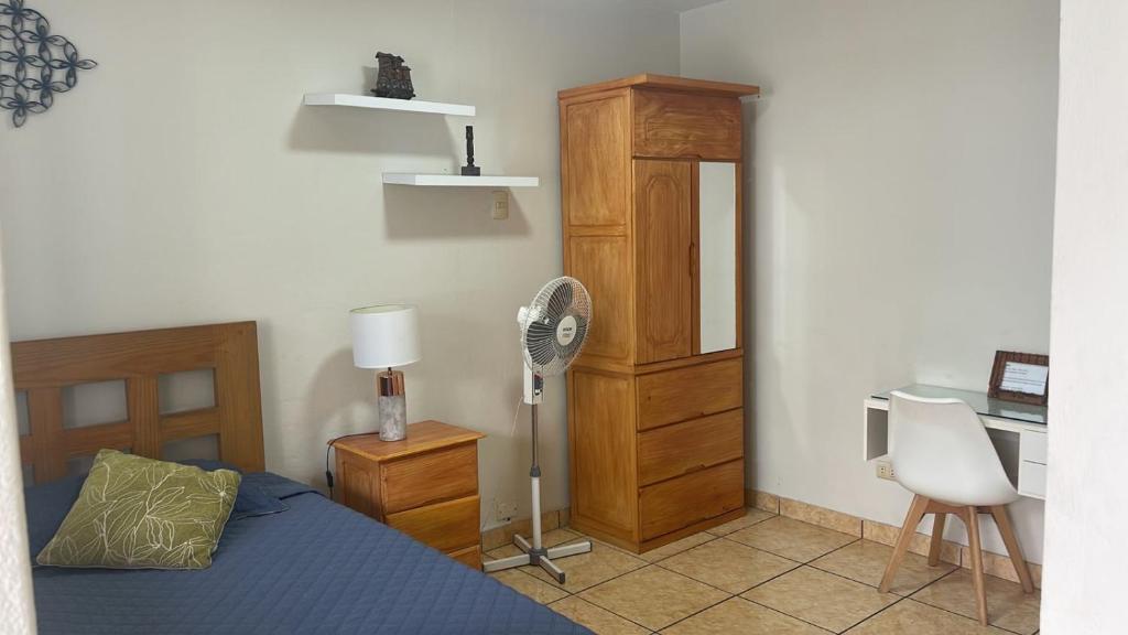 1 dormitorio con 1 cama, escritorio y ventilador en Habitación Alborada 2 con baño privado, en Lima