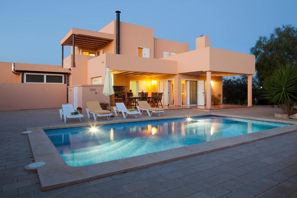 a villa with a swimming pool in front of a house at Ca na Catalina in Sant Jordi