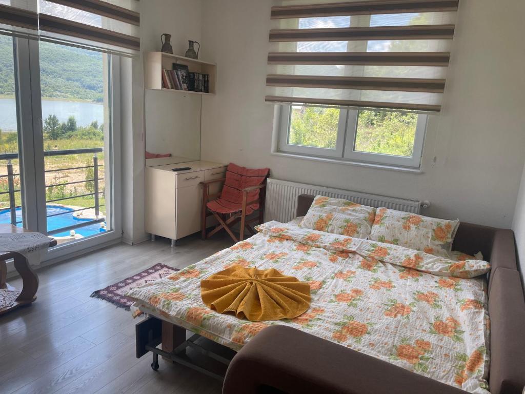 Schlafzimmer mit einem Bett, einem Schreibtisch und Fenstern in der Unterkunft LUX Villa Mavrovo in Mavrovo-Nationalpark