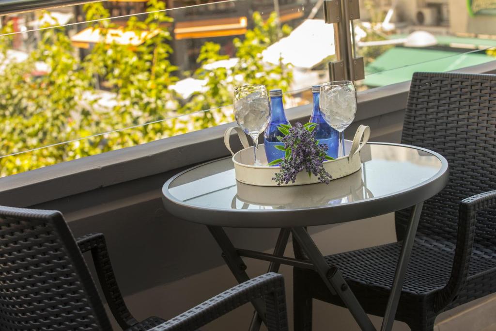 a small table with glasses and flowers on a balcony at Blazer Residence in Larnaka