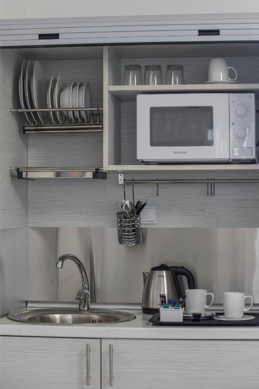 a kitchen with a sink and a microwave at Blazer Residence in Larnaka
