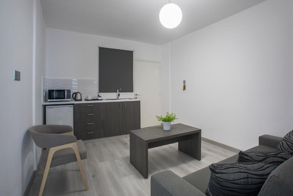 a living room with a couch and a table and a kitchen at Blazer Residence in Larnaka