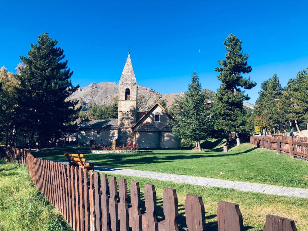 an old church with a fence in front of it at Auron Joli appartement in Auron