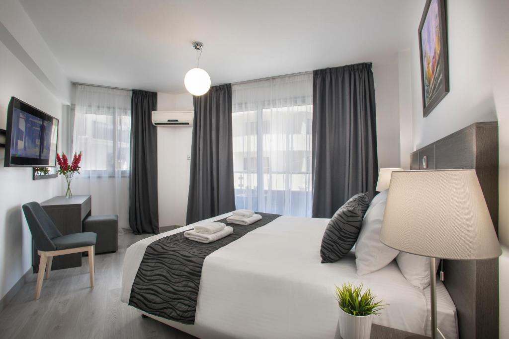 a bedroom with a large white bed and a chair at Blazer Residence in Larnaka